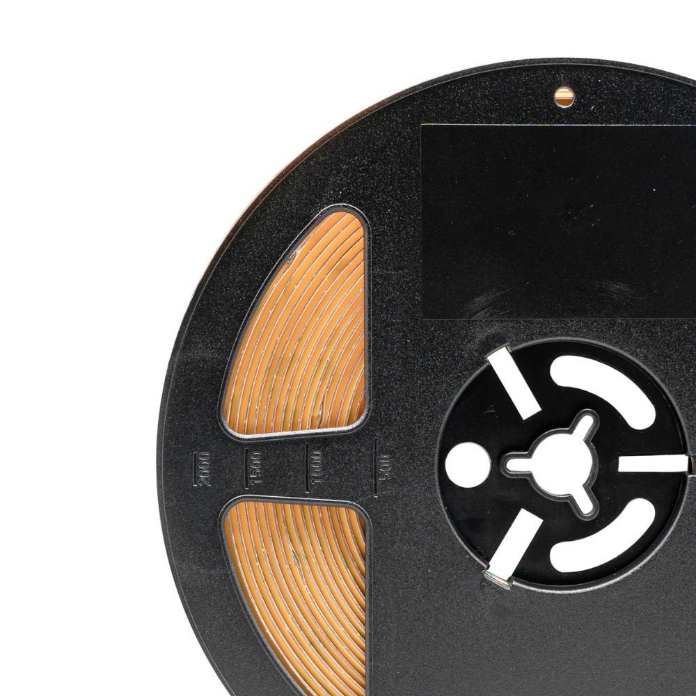 Close-up of a reel to reel tape with visible label on a white background